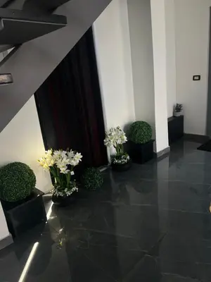 a hallway with three vases with flowers in them at Villa Ohaio in Amman