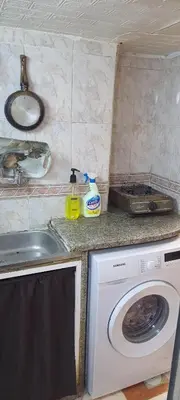 a kitchen with a sink and a washing machine at Stone house in Amman