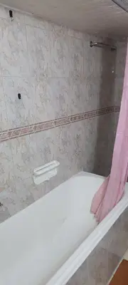 a bath tub with a pink shower curtain in a bathroom at Stone house in Amman