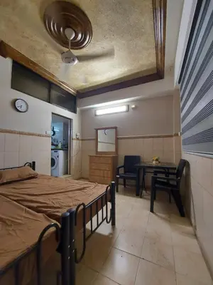 a bedroom with a bed and a desk and a table at Stone house in Amman