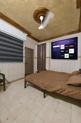 a bedroom with a bed with a tv on the wall at Stone house in Amman