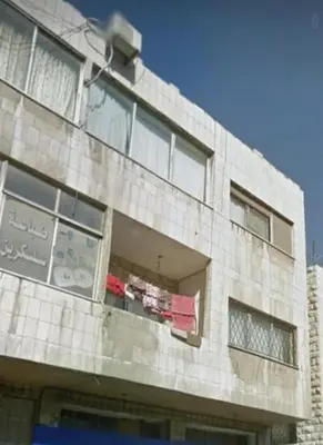 a building with clothes hanging out of a window at Stone house in Amman