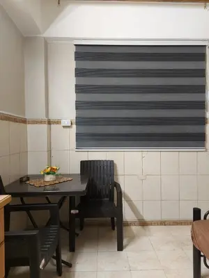 a dining room with a table and chairs and a window at Stone house in Amman