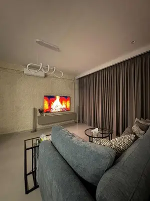 a living room with a blue couch and a fireplace at Roof 99 in Amman