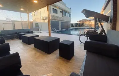 a living room with couches and a swimming pool at For daily, weekly monthly and yearly stays in Amman