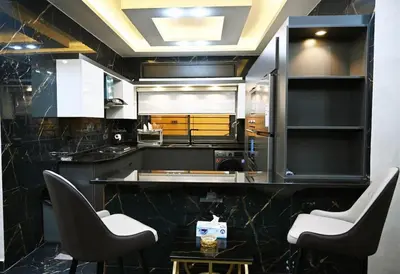 a kitchen with a counter with two chairs and a table at Sky Villa in Amman