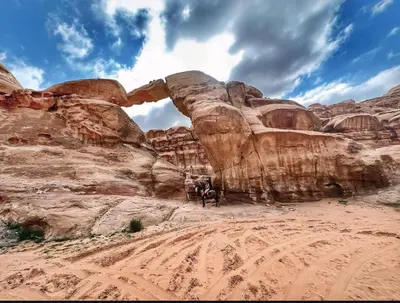 a group of people standing in front of an arch at Rum Laura luxury camp in Wadi Rum