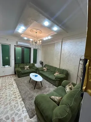 a living room with green couches and a table at Toum's Apartments 2 in Amman