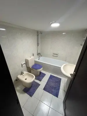 a bathroom with a toilet and a sink and a tub at Toum's Apartments 2 in Amman