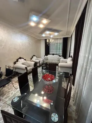 a living room with a table and a couch at Toum's Apartments 2 in Amman