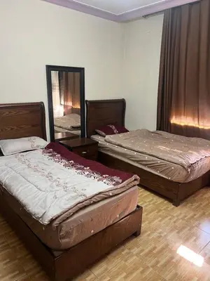 a room with two beds and a mirror at كرم الضيافة in Amman