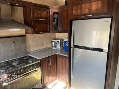 a kitchen with a white refrigerator and wooden cabinets at كرم الضيافة in Amman