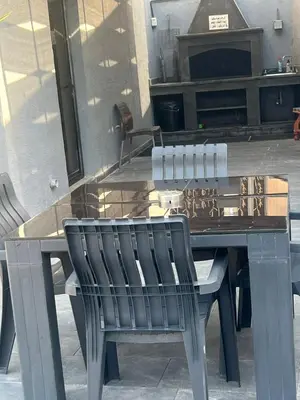a wooden table with two chairs sitting next to a fireplace at Ohio villa in Sowayma