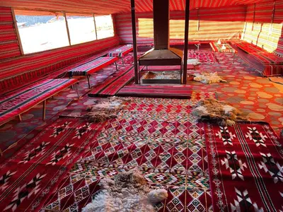 a room with benches and a rug on the floor at Desert Key Camp in Wadi Rum