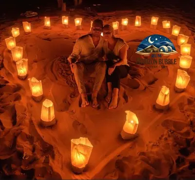 a couple sitting in the middle of a cake with candles at RUM HORIZON BUBBlE LUXURY CAMP in Wadi Rum