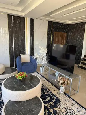a living room with a table and a television at 2bd apartment sport city in Amman