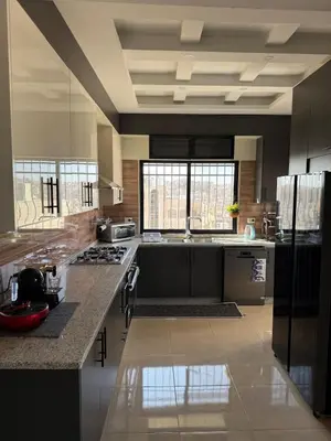a large kitchen with black and white appliances at 2bd apartment sport city in Amman