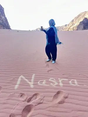 a woman standing in the desert with the word vacation written in the sand at Sleeping amidst the natural beauty of Wadi Rum, and living like a Bedouin in Aqaba