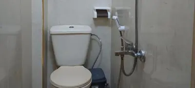 a bathroom with a white toilet and a shower at Stone house in Amman