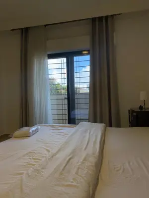 a white bed in a bedroom with a window at dabouq 3bedroom near all services JRE in Amman