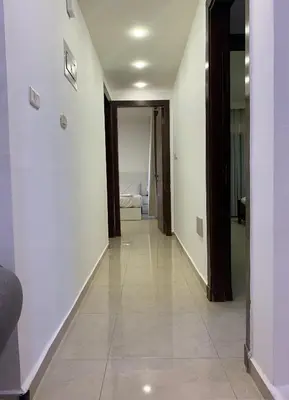 a hallway with white walls and a room with a bed at dabouq 3bedroom near all services JRE in Amman