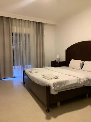 a bedroom with a large bed and a window at dabouq 3bedroom near all services JRE in Amman