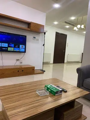 a living room with a coffee table and a flat screen tv at Luxurious 3 Bedroom Apartment in Heart of Amman in Amman