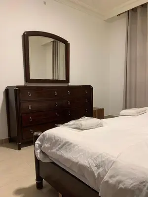 a bedroom with two beds and a dresser with a mirror at Luxurious 3 Bedroom Apartment in Heart of Amman in Amman