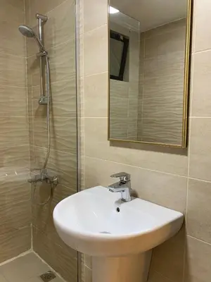 a bathroom with a sink and a shower with a mirror at Luxurious 3 Bedroom Apartment in Heart of Amman in Amman