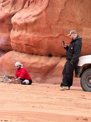 a man taking a picture of two men in the desert at Rum Horizon Camp& Tours in Wadi Rum