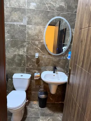 a bathroom with a toilet and a sink and a mirror at Sports city 2bd room in Amman
