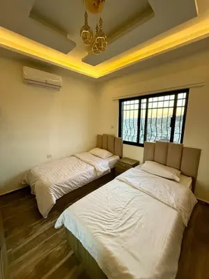 a bedroom with two beds and a window at Sports city 2bd room in Amman