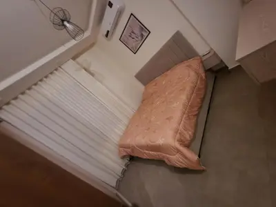 a bed in a small room with a pillow at Cozy Appartment In Shmessani in Amman