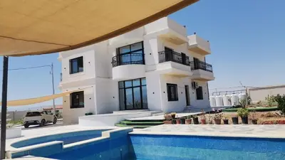 a white house with a swimming pool in front of it at Rest Sea Chaliet & Farm