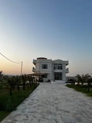 a large white house with a driveway in front of it at Rest Sea Chaliet & Farm