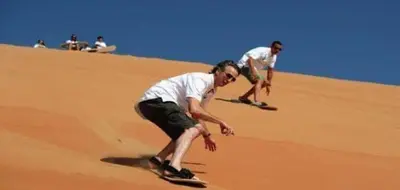two men on skateboards on a sand hill at Wadi Rum Bubble Dream in Wadi Rum