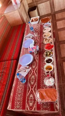 a long table with plates and dishes on it at Wadi Rum Bubble Dream in Wadi Rum