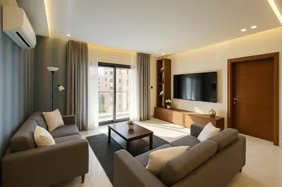 a living room with two couches and a flat screen tv at Central Amman Twin Towers Apartment 2 in Amman