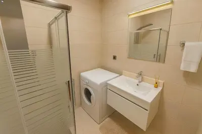 a bathroom with a washing machine and a sink at Central Amman Twin Towers Apartment 2 in Amman