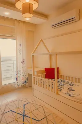 a childs bedroom with a bunk bed and a window at Elite Apartment Compound in Amman