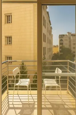 two chairs on the balcony of a building at Elite Apartment Compound in Amman