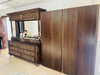 a large wooden cabinet with a mirror in a room at Furnished Villa in Andalusian Compound for Rent in Madaba