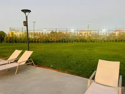 a couple of chairs sitting next to a field at Furnished Villa in Andalusian Compound for Rent in Madaba