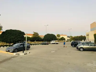 a person walking in a parking lot with cars at Furnished Villa in Andalusian Compound for Rent in Madaba
