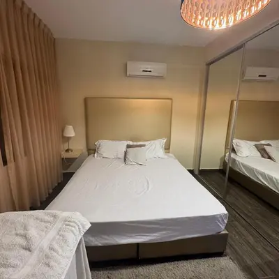 a bedroom with a large white bed and a chandelier at عبدون الشمالي -بالقرب من السفارة البريطانية in Amman