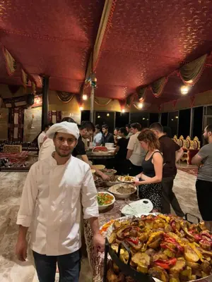 a chef standing in front of a table of food at BUBBLE lUXURY RUM JNOPE CAMP in Wadi Rum