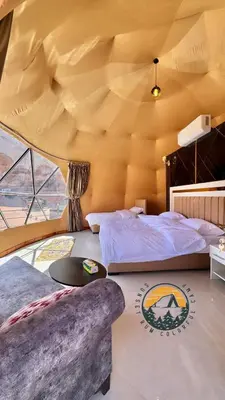a bedroom with two beds and a large ceiling at WADI RUM BUBBlE AOSE CAMP in Wadi Rum
