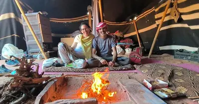 a man and a woman sitting in front of a fire at Wadi Rum Wanderer cmap in Wadi Rum