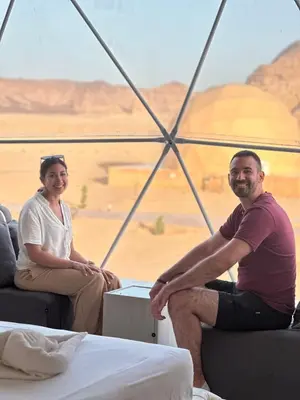 a man and a woman sitting on a boat in the desert at RUM NADINE LUXURY CAMP & Bubbles Hotel in Wadi Rum