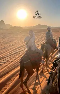 a group of people riding horses in the desert at RUM NADINE LUXURY CAMP & Bubbles Hotel in Wadi Rum
